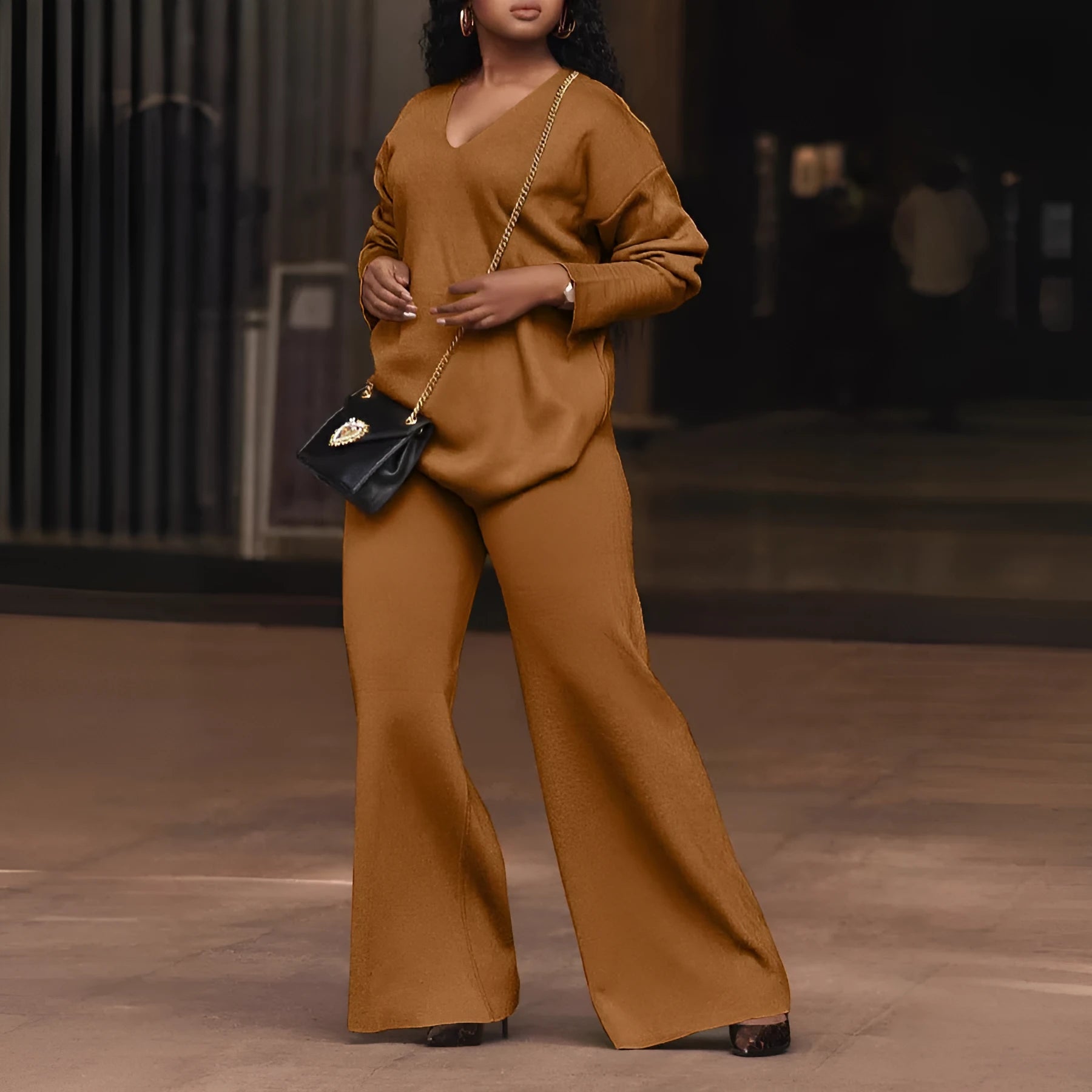 Women's brown thickened velvet two-piece suit with split sleeve top and trousers on a hanger.