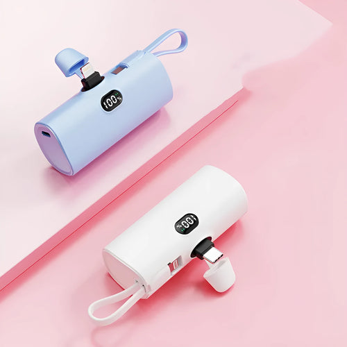Capsule shaped digital display wireless power bank in multiple colours showing its compact size and built-in plug.