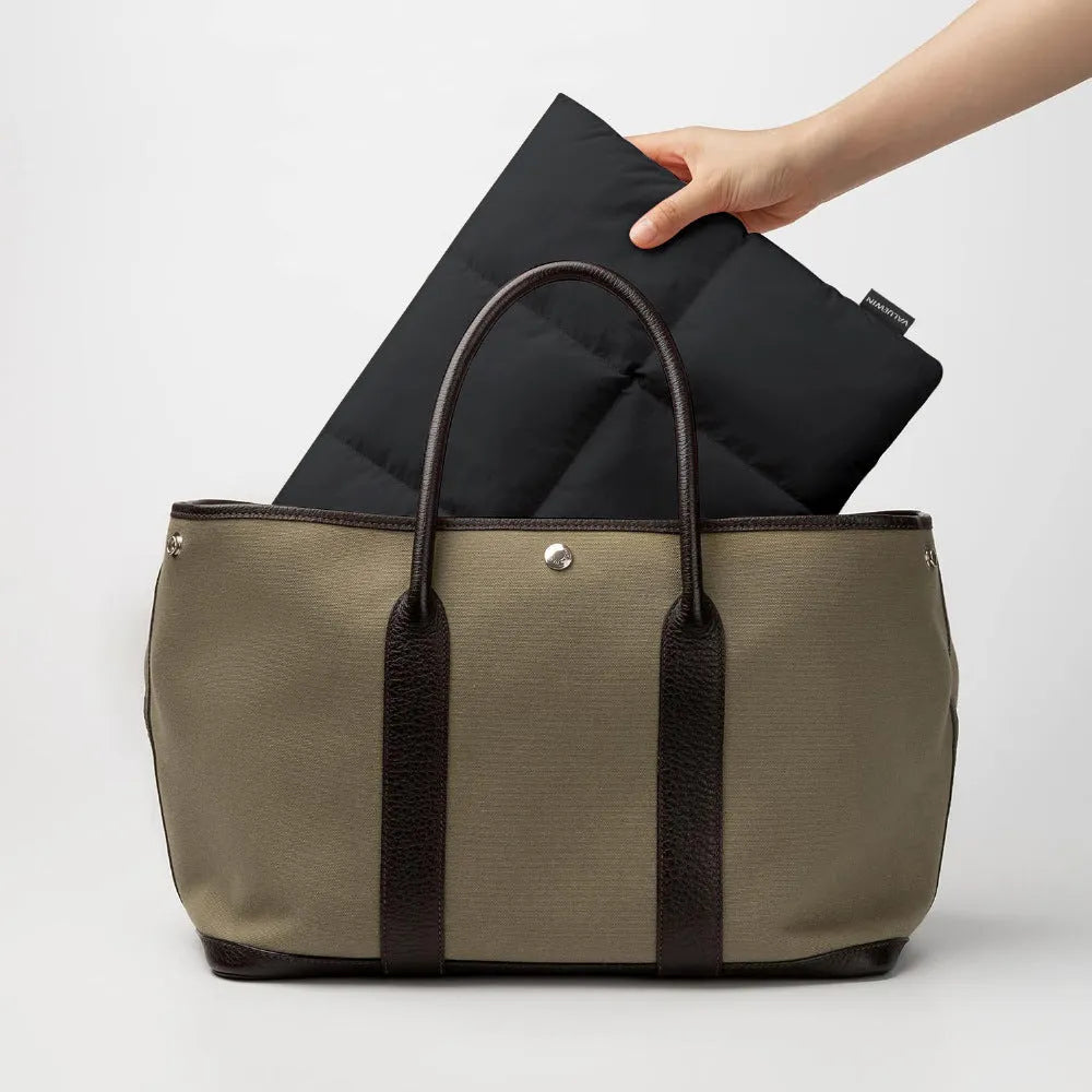 Soft black retro-style laptop sleeve for 13 to 15.6 inch laptops on a table.
