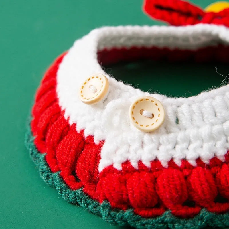 Hand-woven red and white Christmas bow knit collar scarf for a cat on a festive background.