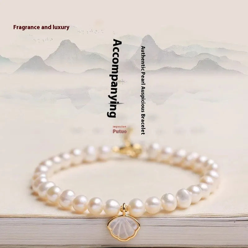 A women's freshwater pearl bracelet with a fan-shaped shell clasp, shown in both elastic and extension chain fastening styles.