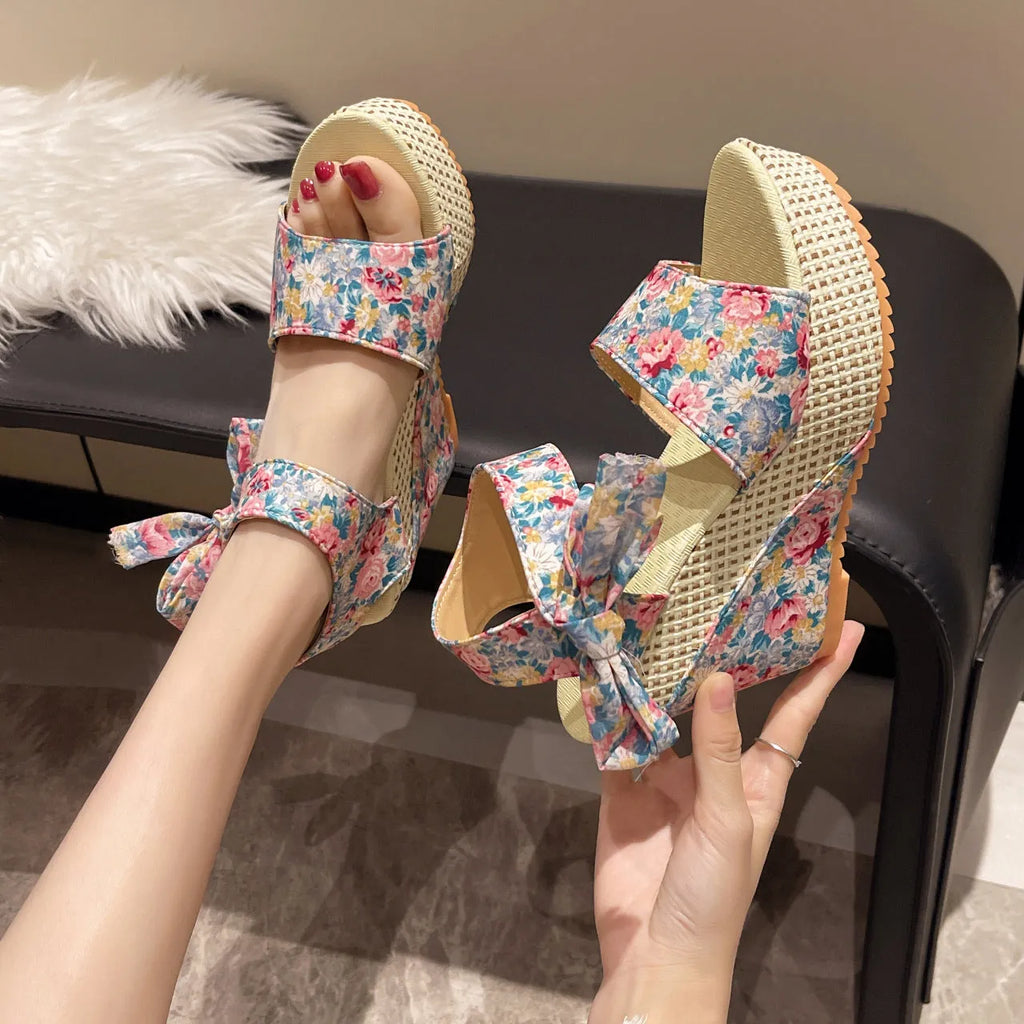 Women's floral wedge sandals with peep toe and adjustable ankle strap buckle.