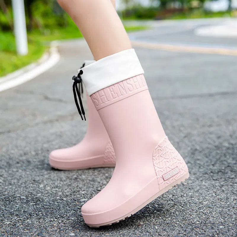 Women's solid colour PVC rain boot with non-slip sole in apricot, black, brown, or pink.