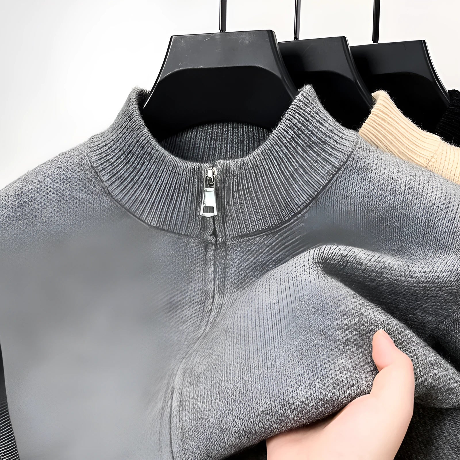 Man wearing a thick grey stand collar knitted cardigan with a zipper front.