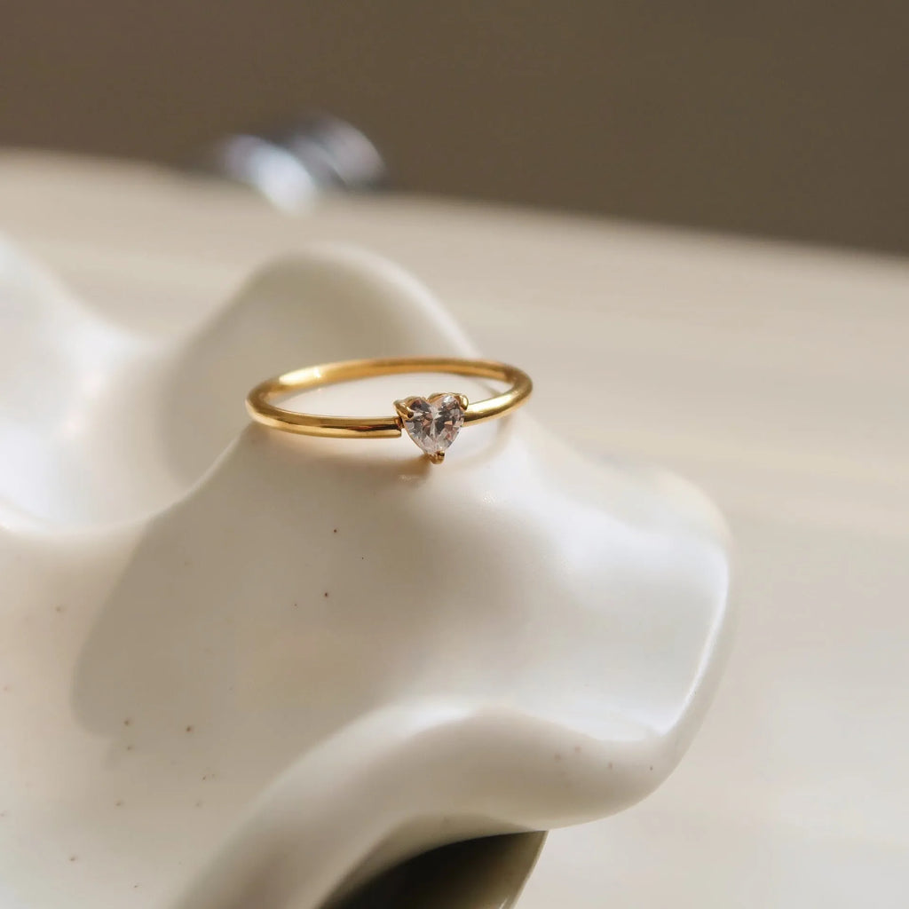 Golden love heart stainless steel ring showing heart shape design on female hand