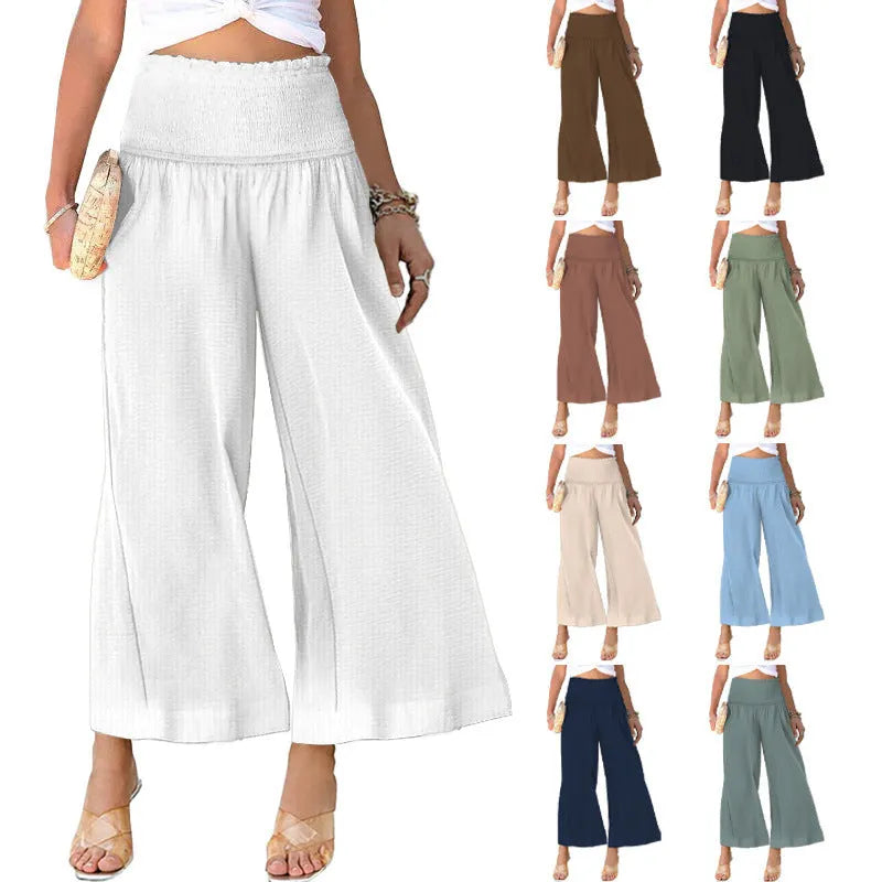 A woman wearing high-waist, pleated, straight-leg cropped trousers in a casual setting.