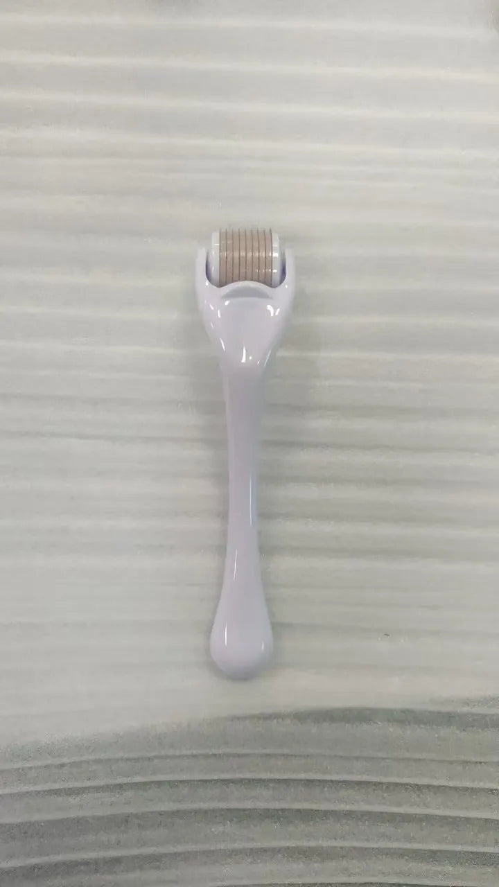 540 micro needle roller tool with black handle and coloured wheel on a white background.