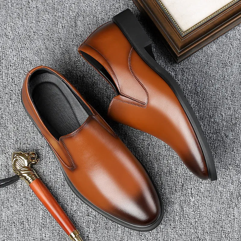 Men's black low-top slip-on leather shoes with a rubber sole and sewing line detailing.