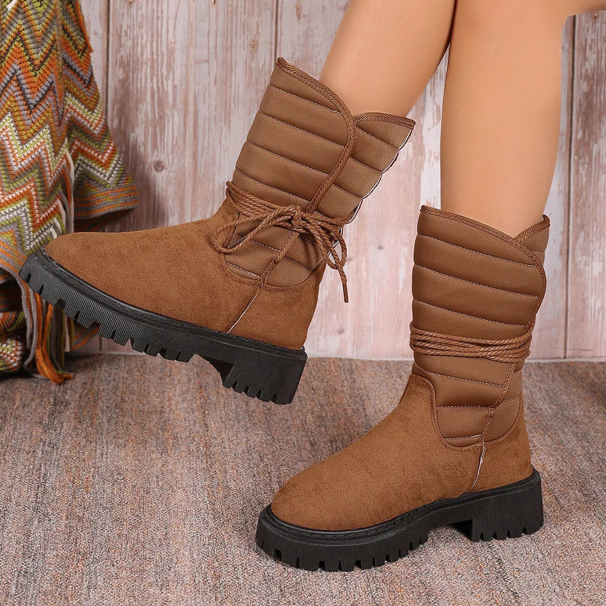 Women's black chunky heel snow boots with lace-up design and fleece lining on a high-top suede upper.
