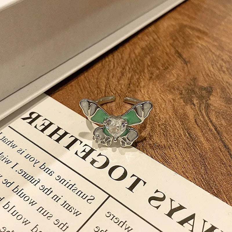 Creative butterfly design women's ring in copper with oil drip finish, showing an open loop style.