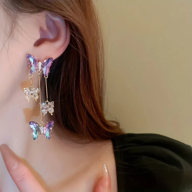 Silver Needle Crystal Flowers Blue Purple Butterfly Tassel Drop Earrings on a white background.