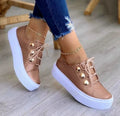 Women's white lace-up casual flats with silver rivet details on a low-top round toe shoe.