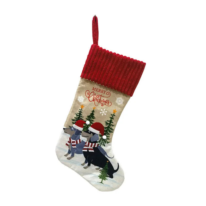 Red and green cloth Christmas stocking pendant for pets, hanging on a tree branch.