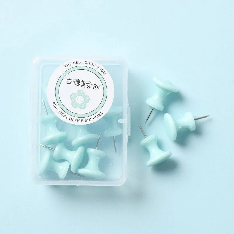 Plastic push pins in cherry blossom pink, mint green, and lavender colours, showing both large and small sizes on a white surface