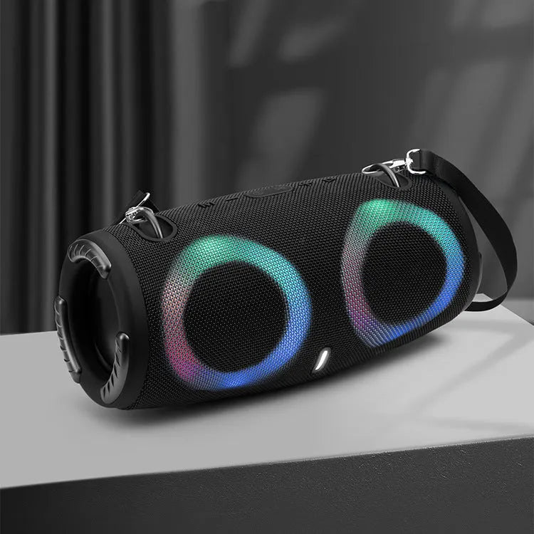 War Drum portable Bluetooth speaker with RGB lights in camouflage finish, showing carry strap and control buttons.