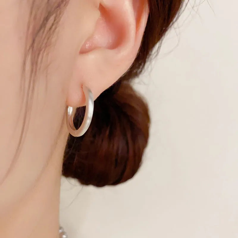Geometric round women's ear clip with eyelet detail in gold or silver finish