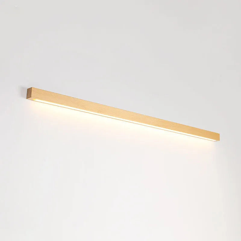 Walnut colour long wooden strip wall lamp with integrated LED lighting mounted on a wall.