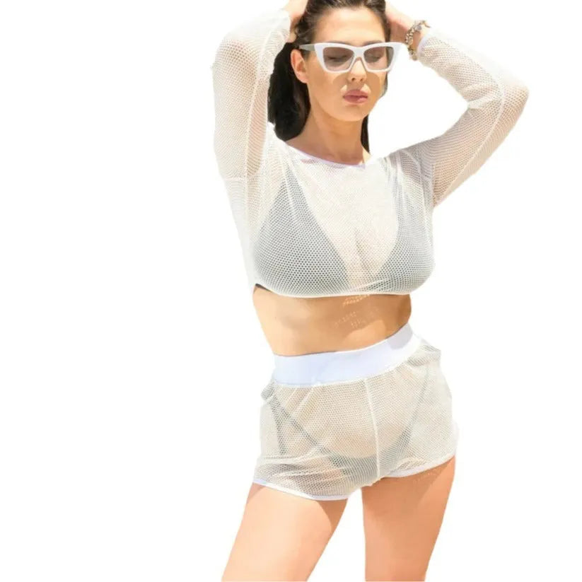 White transparent strappy women's two-piece swimsuit cover-up on a beach background.
