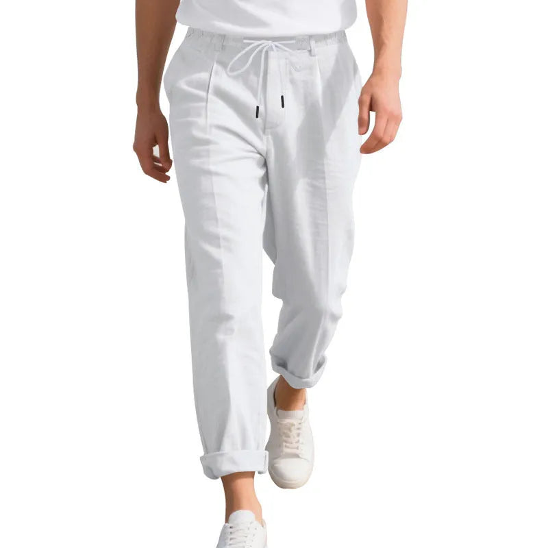 Man wearing light khaki linen casual trousers with a drawstring waist and straight-leg fit.