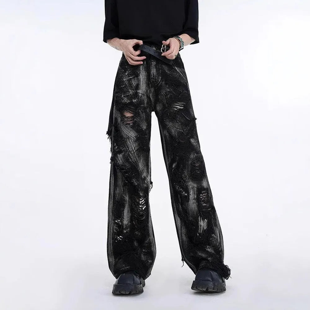 Men's grey pink graffiti detail denim trousers laid flat, showing mid-waist and zipper fly.