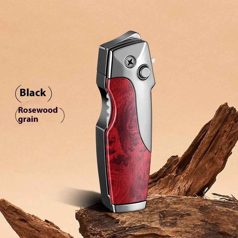 Closed metal folding lighter with integrated knife in a carbon fibre finish, showing the safety lock and refill valve.