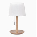 Walnut-coloured solid wood bedside lamp with a white cloth shade on a wooden surface.