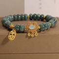 Close-up of a women's bracelet with green emerald jade and silver alloy abacus beads and a safety lock clasp.