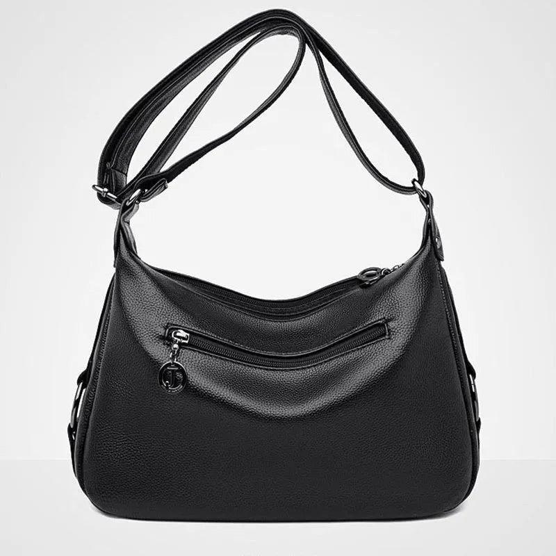 Blue horizontal square women's crossbody bag with a soft handle and zipper opening, showing organiser pockets inside.