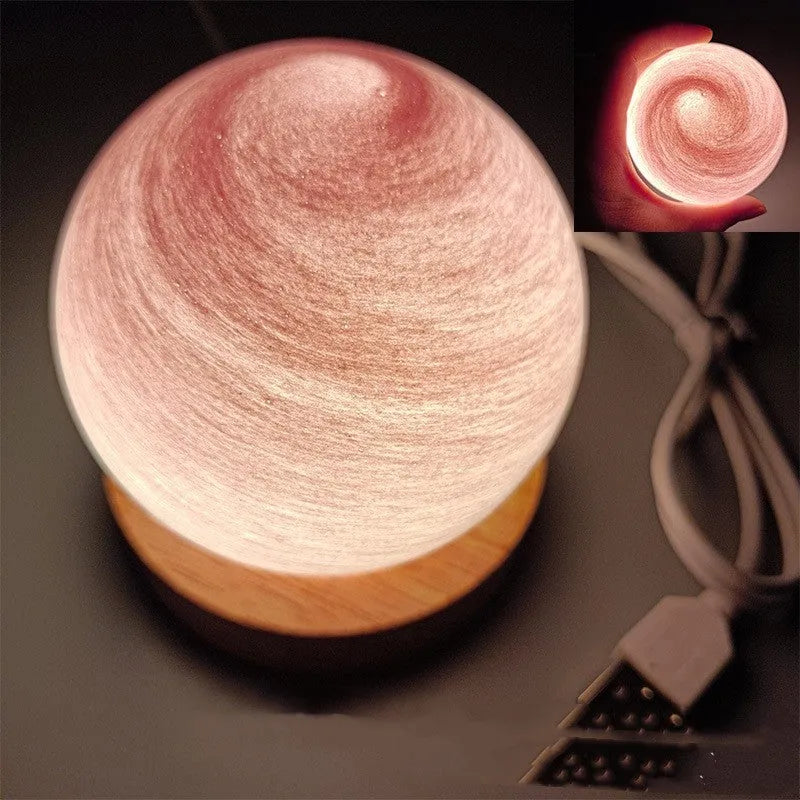 Modern planet-shaped USB night light with dimming on a desk.