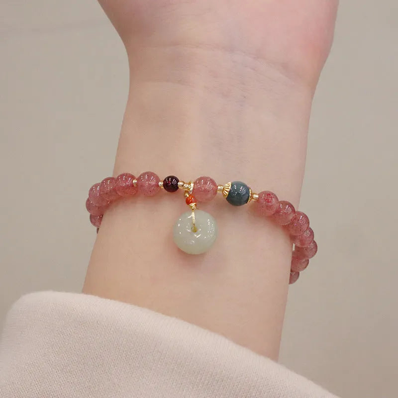 Geometric strawberry quartz women's bracelet with a lucky bag charm and silver safety buckle on a white background.