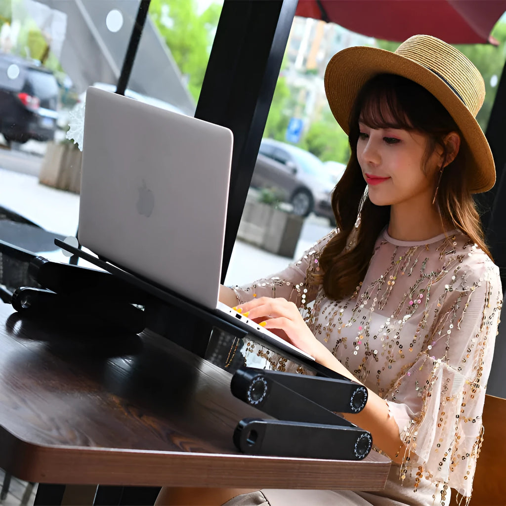 Folding metal laptop desk on bed with cooling fans and mouse board