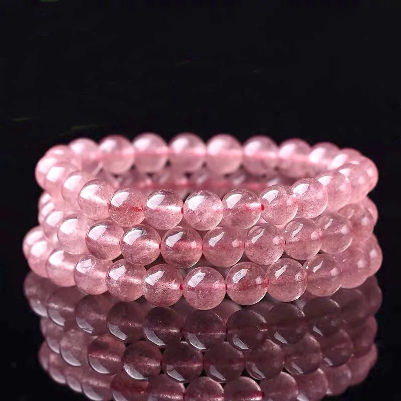 Women's adjustable bracelet with round, polished strawberry quartz crystal beads.
