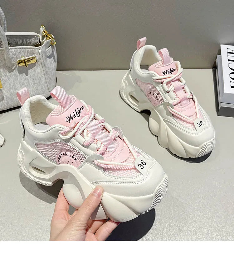 Women's pink casual sneakers with thick sole, cross straps, and mesh lining.