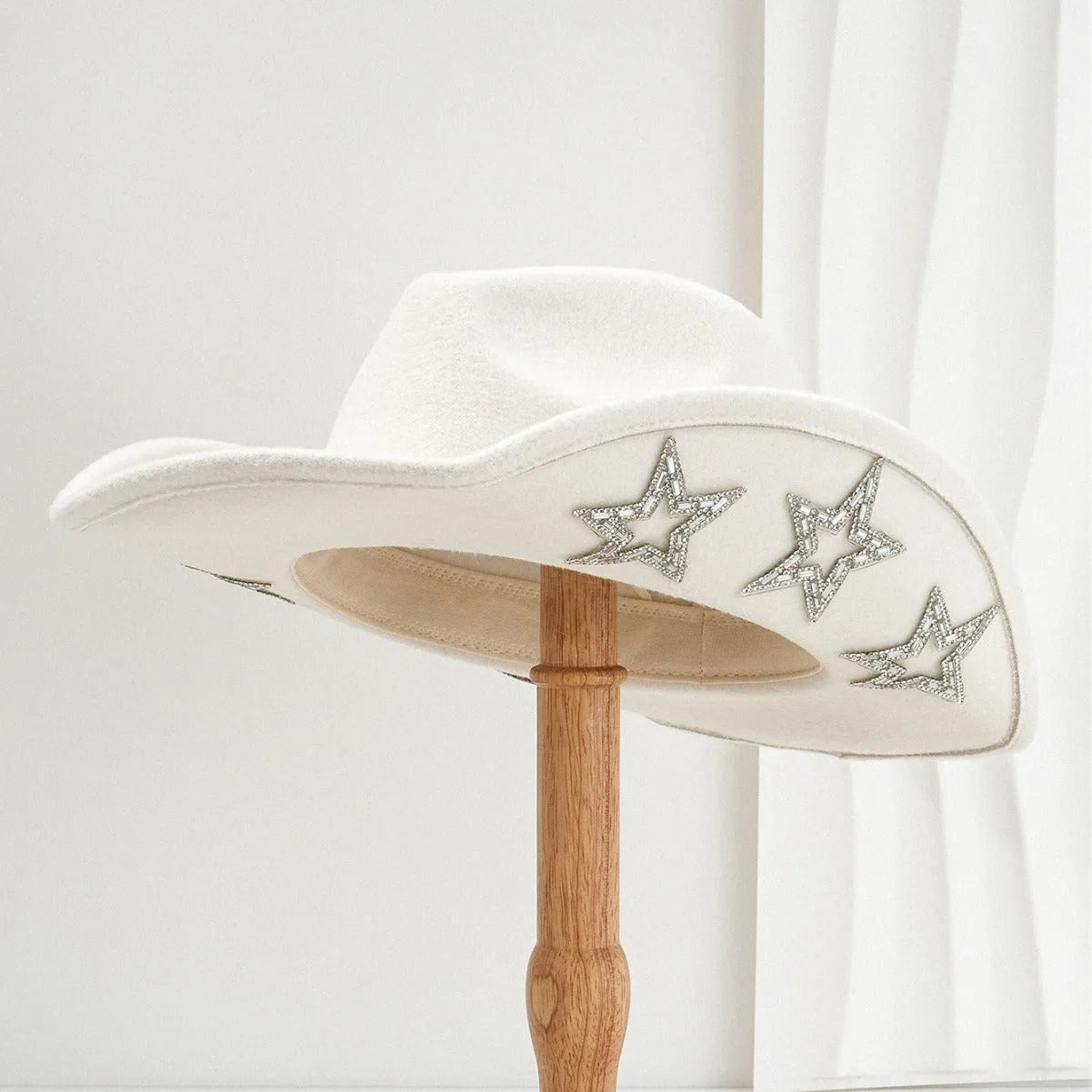 Beige woven polyester western top hat with a conical crown and a hexagonal star decoration on the front.