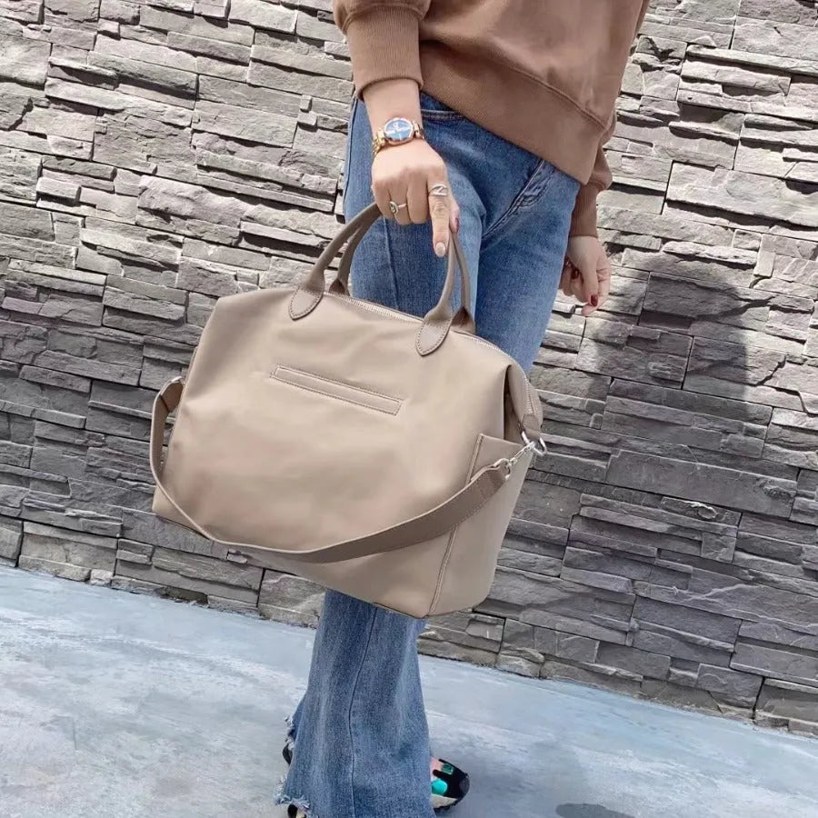 Black waterproof nylon simple shoulder bag with shoulder strap, shown next to light khaki colour option.