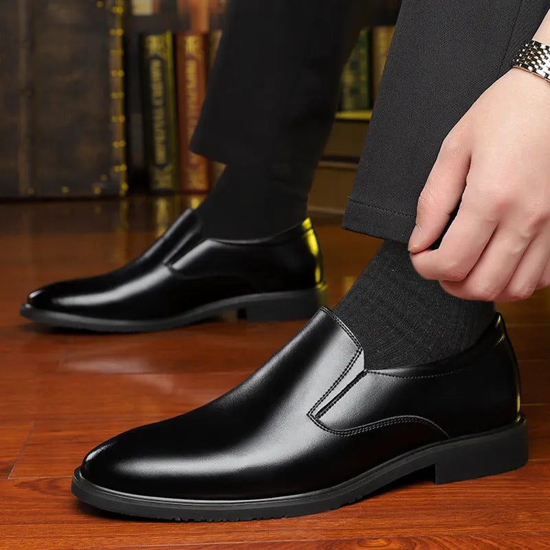 Men's black low-top slip-on leather shoes with a rubber sole and sewing line detailing.