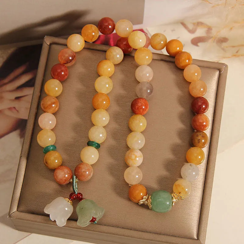 Natural jade multi-strand bracelet for women with an orchid pendant and adjustable clasp.
