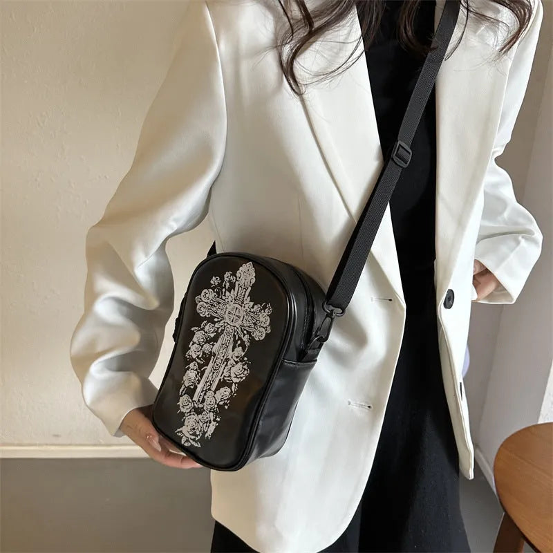 Black mini square crossbody bag with orange Halloween graffiti print of cartoon pumpkin, ghost, and bat.