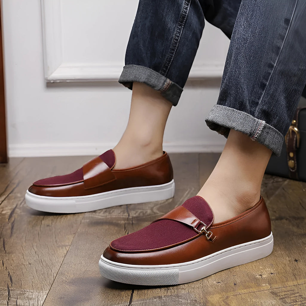 Men's black faux leather slip-on loafers featuring a gold horsebit buckle and a round toe.