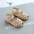 Kids buckle-toe soft sole woven sandals in white, black, and pink on a light background