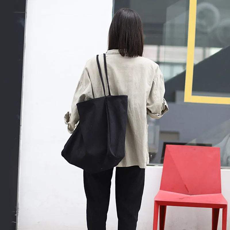 Large canvas shoulder tote bag in solid colour with soft handle, open top, and internal phone pocket
