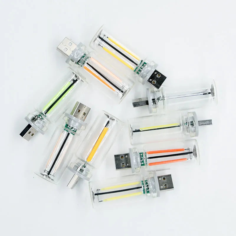 Small transparent glass USB touch night lamp with warm white light on a desk