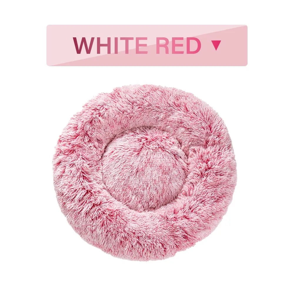 Fluffy grey donut-shaped dog bed with high plush sides on a wooden floor.
