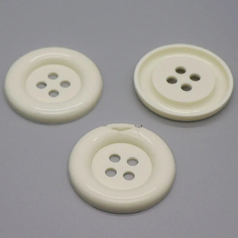 Oversized round edge plastic button with four holes in various colours and diameter sizes