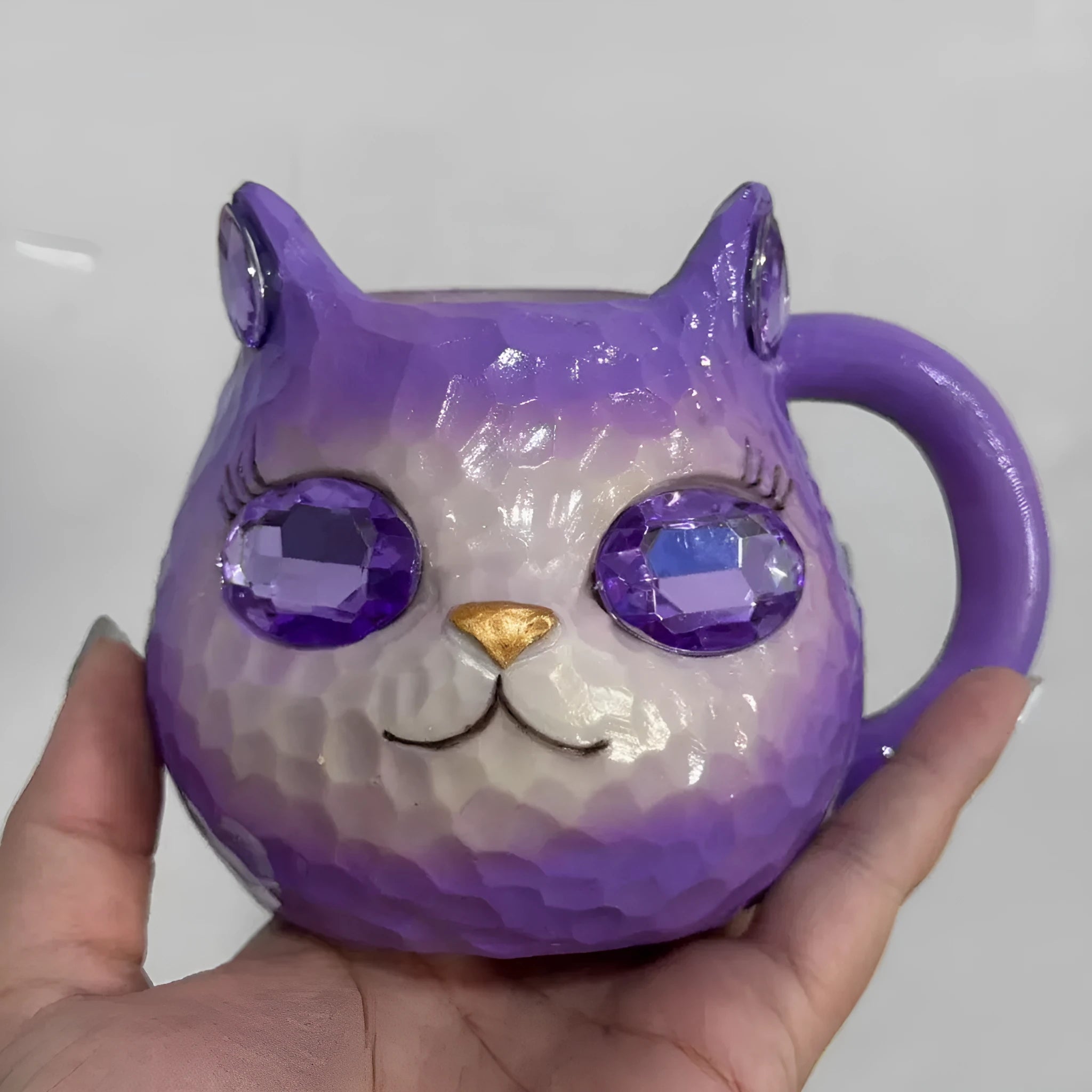 Colourful resin cat cup figurine on a shelf, shown in purple, green, blue, and pink colour options.