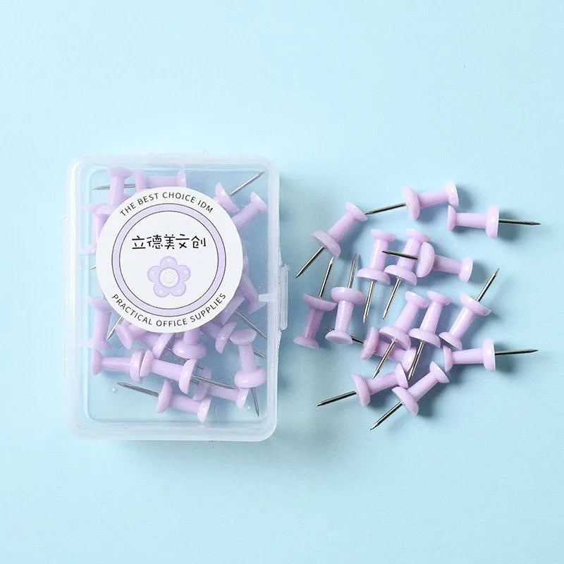 Plastic push pins in cherry blossom pink, mint green, and lavender colours, showing both large and small sizes on a white surface