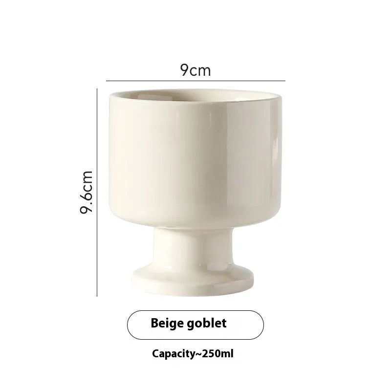 Handmade irregular solid colour ceramic mug on a table, showing its unique shape.