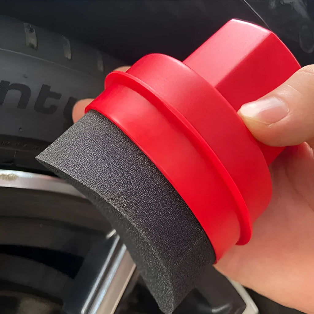 Black car tyre polishing sponge brush with a red lid, showing its size next to a car tyre.