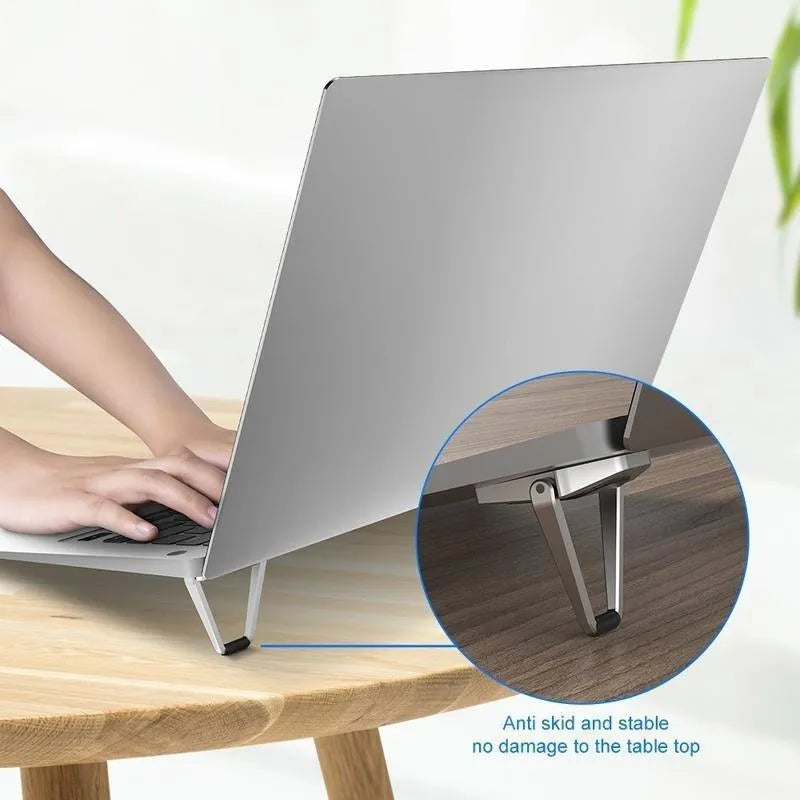 Silver foldable aluminium laptop bracket shown next to 3M adhesive glue on desktop