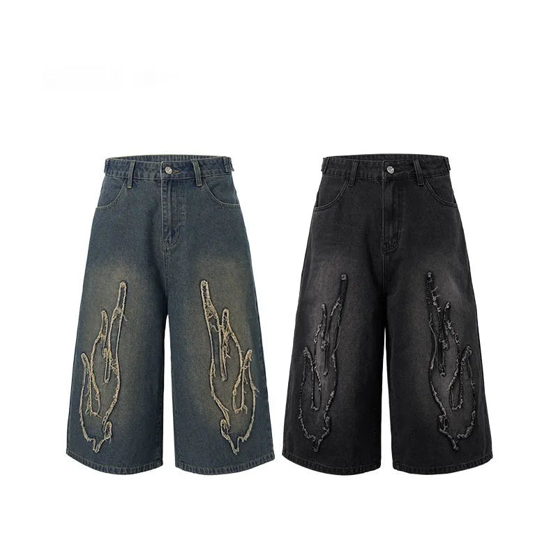 Men's black denim shorts with flame embroidery patch detail on straight leg cropped design